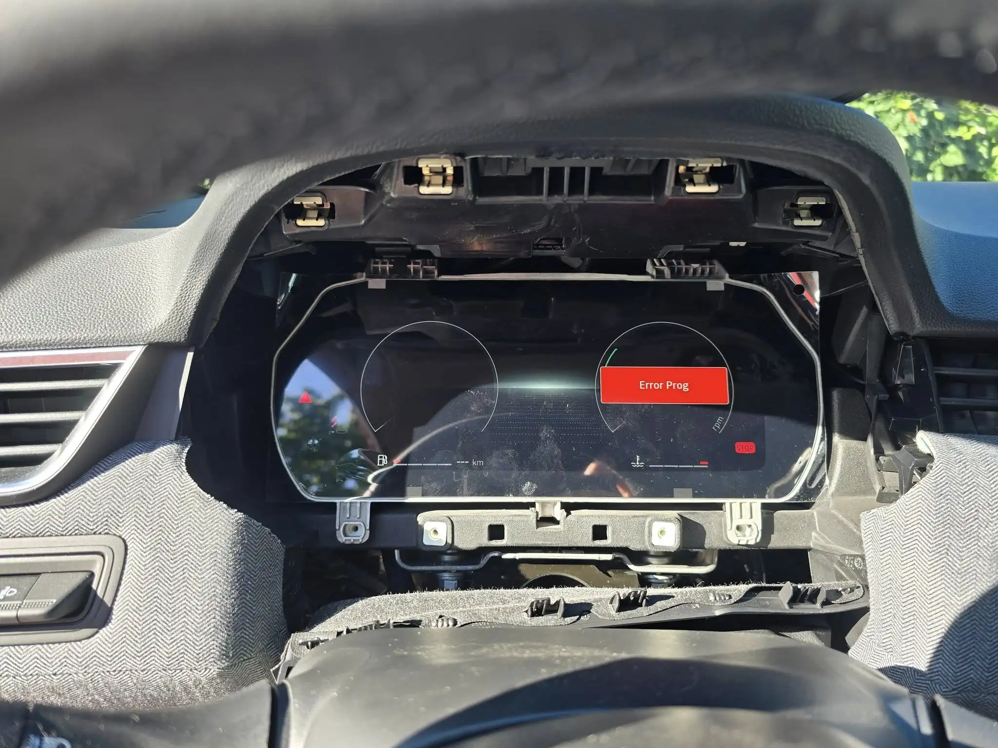 Demontaż systemu multimedialnego w Renault, widoczny wyjęty ekran i wiązki przewodów.